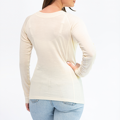 Mujer vista de espaldas usando Primera Capa Camiseta Mujer 100% Lana Merino color claro, cómoda y de calidad.