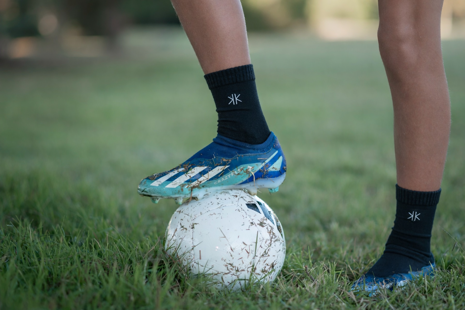 Calcetines Lana Merino Niños/Niñas negros cómodos usados en un partido de fútbol en césped natural.