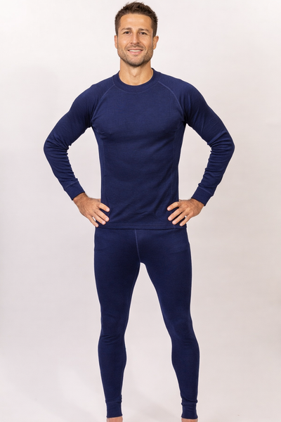 Hombre vistiendo Primera Capa Pantalón Hombre 100% Lana Merino en azul, cómodo y de calidad garantizada.