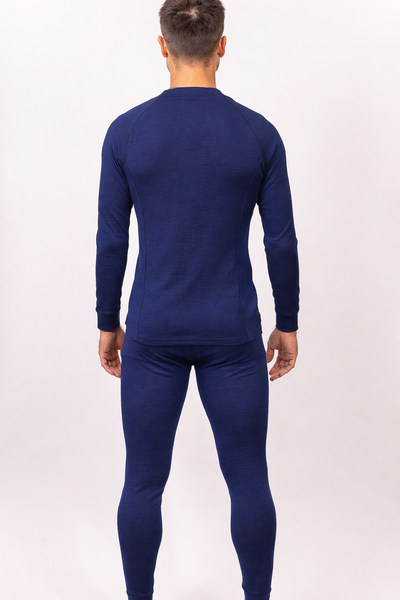 Hombre de espaldas con Primera Capa Pantalón Hombre 100% Lana Merino azul, destacando comodidad y calidad.