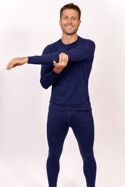 Hombre sonriente estirando brazo con ropa térmica azul, Primera Capa Pantalón Hombre 100% Lana Merino