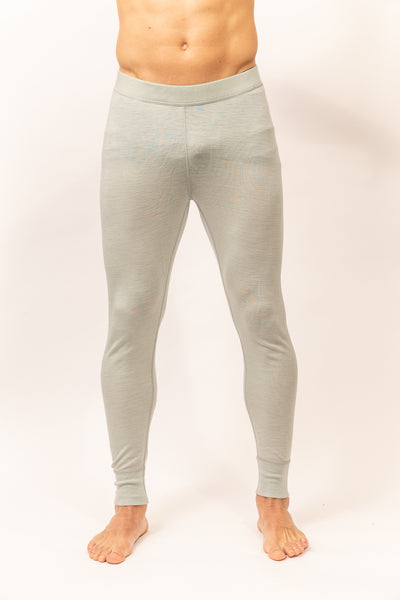 Hombre vistiendo Primera Capa Pantalón Hombre 100% Lana Merino color gris claro, cómodo y ajuste ceñido.