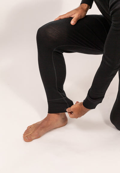 Hombre ajustando primera capa pantalón con tela negra cómodo y suave, Primera Capa Pantalón Hombre 100% Lana Merino
